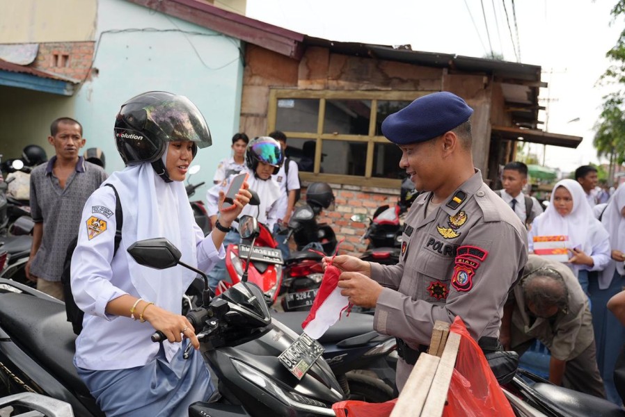 Tingkatkan Rasa Nasionalisme, Brimob Polda Riau Bagikan Bendera Merah Putih ke Masyarakat