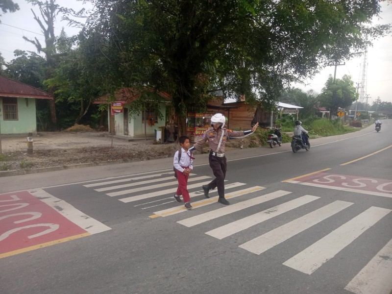 Polsek Bandar Sei Kijang Kembali Laksanakan Pengaturan Arus Lalu Lintas dan Menyebrangkan Anak Sekolah