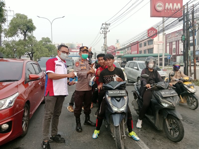 Peduli Kesehatan Warga, PWMOI Riau Bersama Polsek Binawidya Turun ke Jalan Bagikan Masker