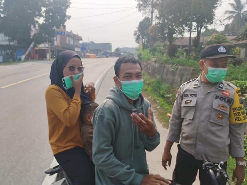 POLSEK BANDAR SEI KIJANG BAGIKAN MASKER GRATIS UNTUK ANTISIPASI DAMPAK ASAP KARHUTLA