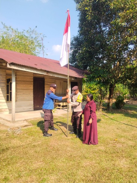 Bhabinkamtibmas Polsek Bandar Sei Kijang Bagikan dan Pasang Bendera Merah Putih ke Warga