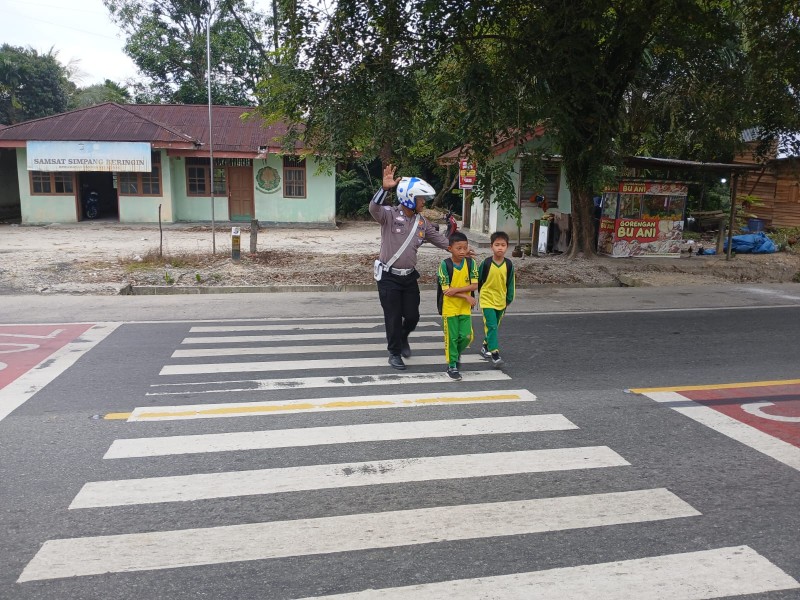Unit Lantas Polsek Bandar Sei Kijang Laksanakan Pengaturan Arus Lalu Lintas Pagi dan Menyebrangkan Anak Sekolah